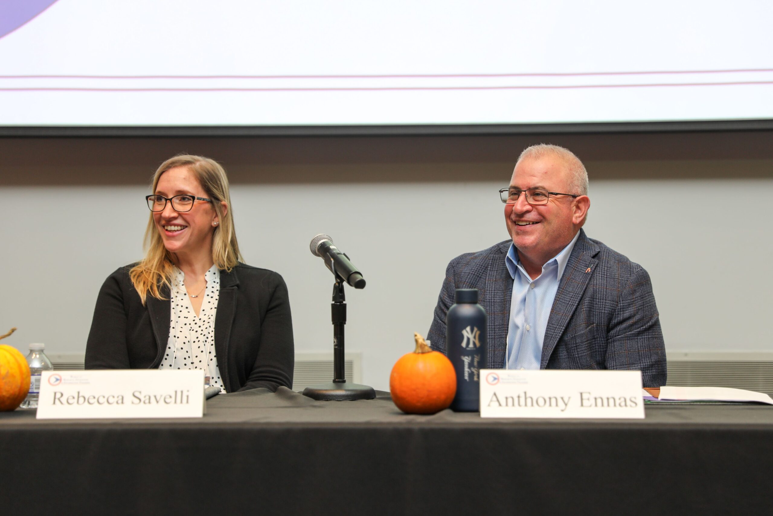 Rebecca Savelli and Anthony Ennas sitting on a panel discussion