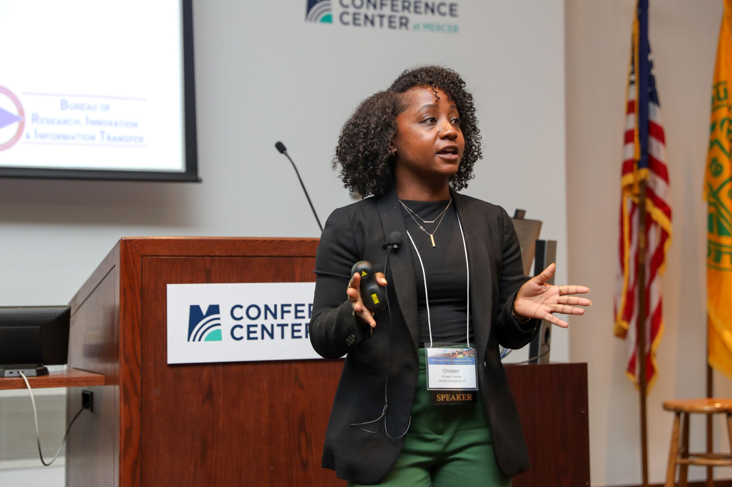 Christen Thomas standing in front of a podium and speaking